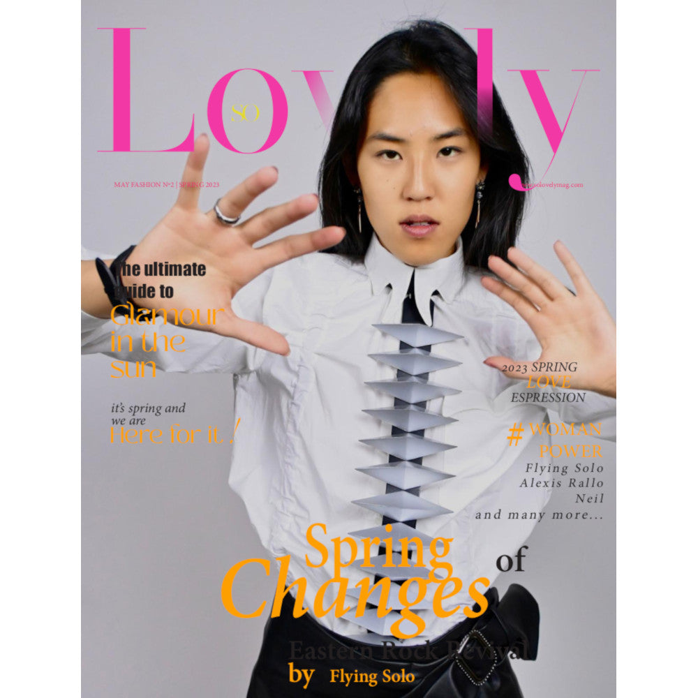 A magazine cover featuring a model in a white shirt with striking folded elements, showcasing vibrant spring fashion and empowerment themes.