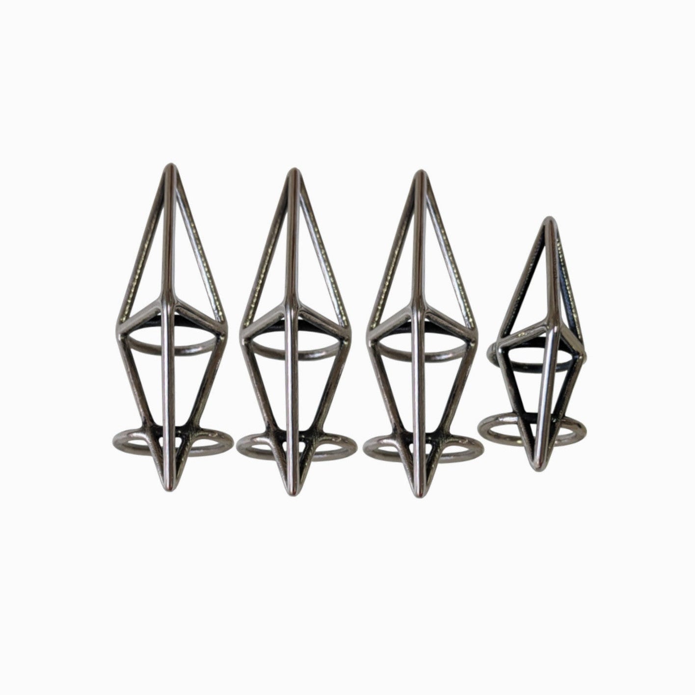 Four metallic geometric rings of varying heights, showcasing a modern design with pointed top and circular bases.