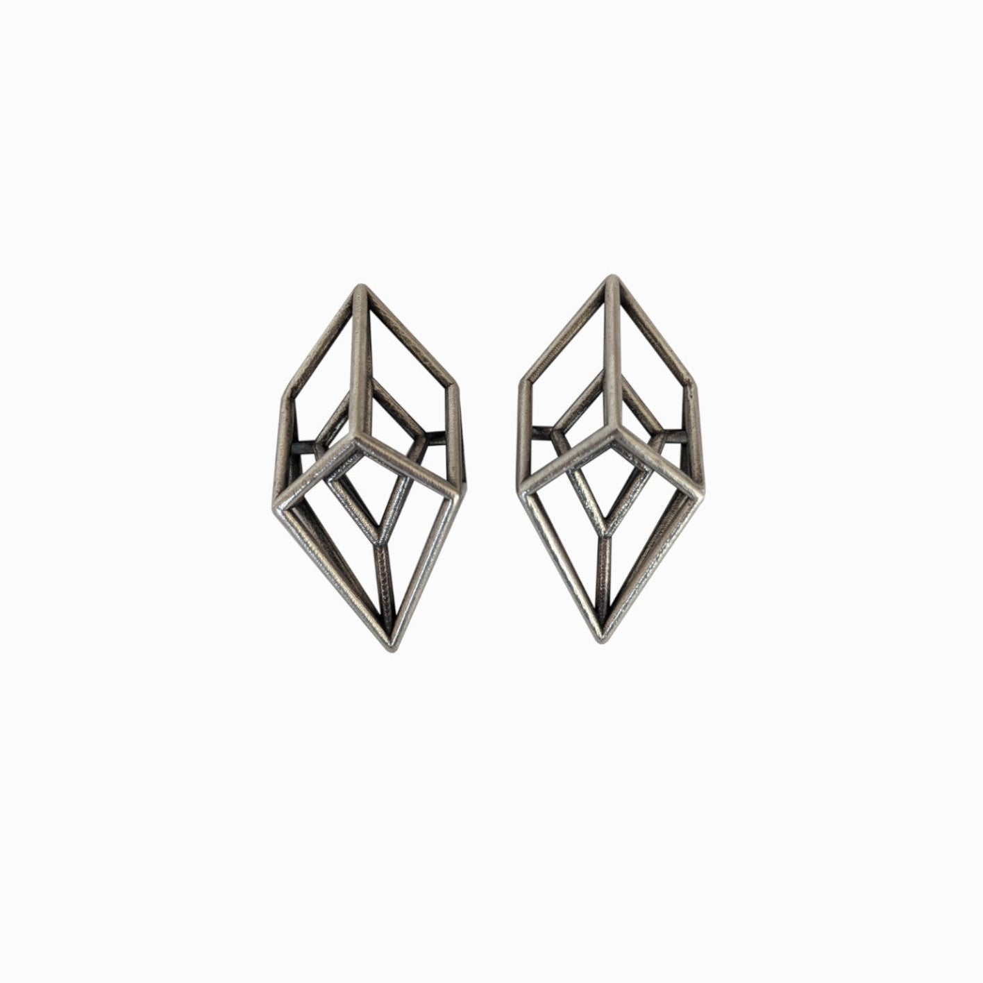Two geometric silver earrings with a modern, angular design resembling three-dimensional crystals.