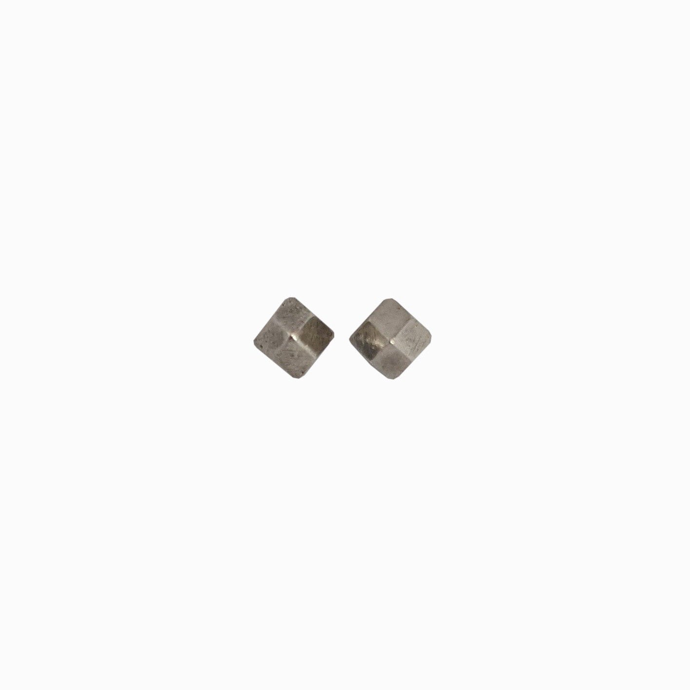 A close-up of two silver metal cube-shaped studs positioned diagonally on a white background.