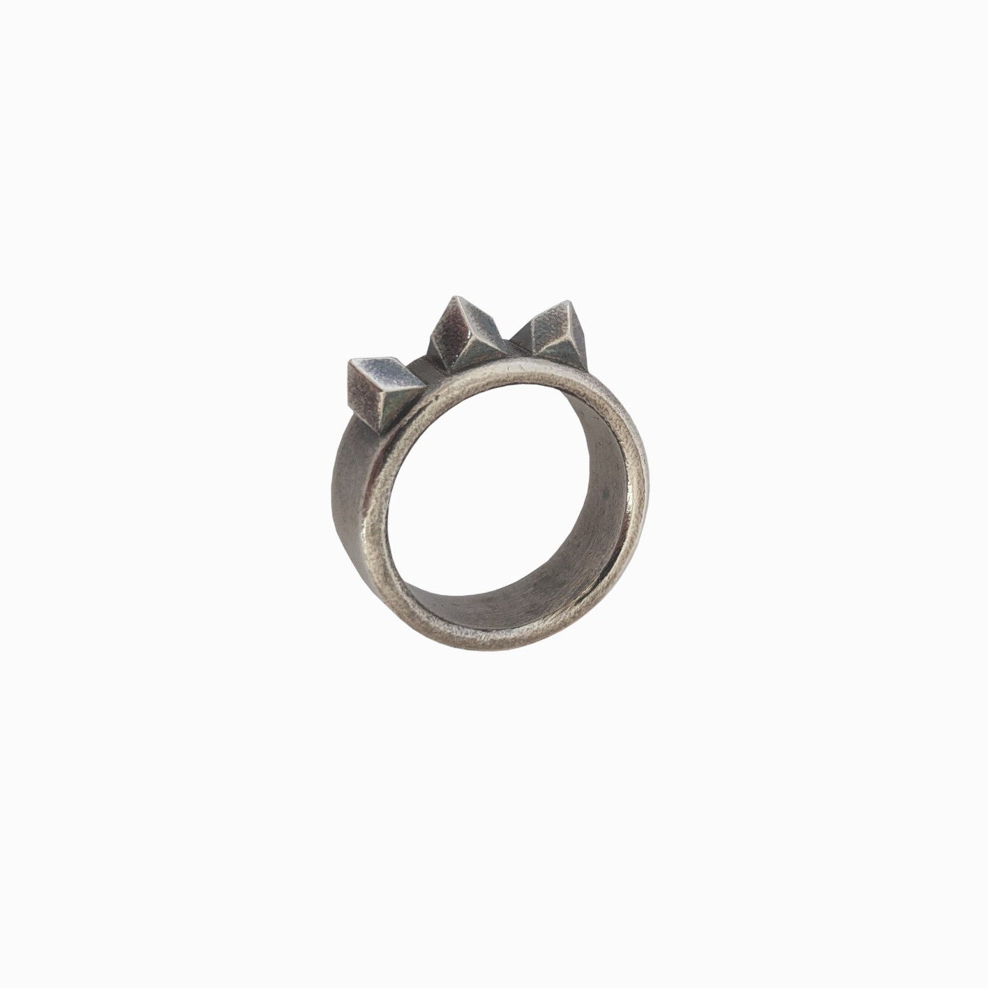 A silver ring featuring three raised triangular adornments at the top, giving it a crown-like appearance.