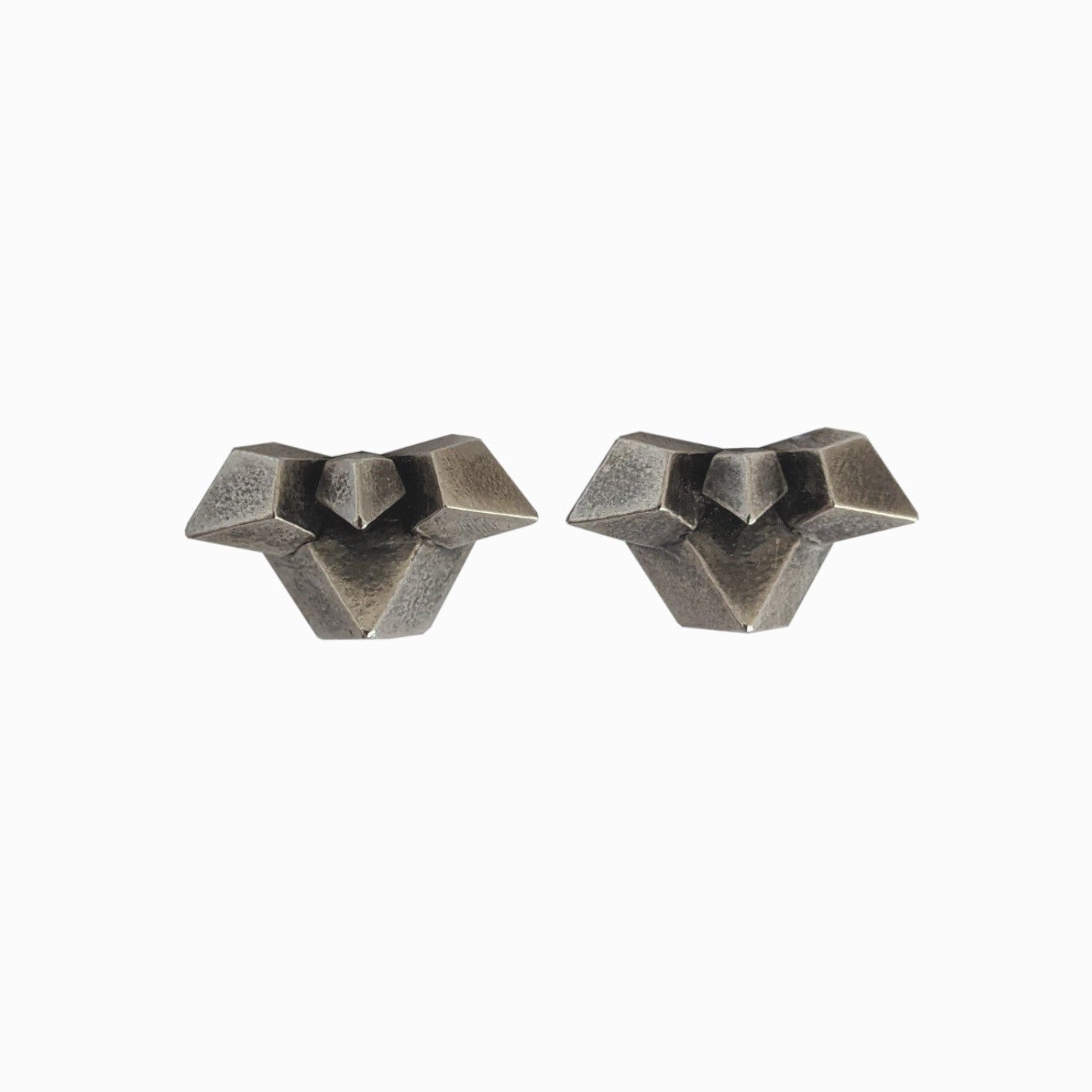Two geometric, metallic earrings with a textured surface, featuring angular designs resembling abstract shapes.