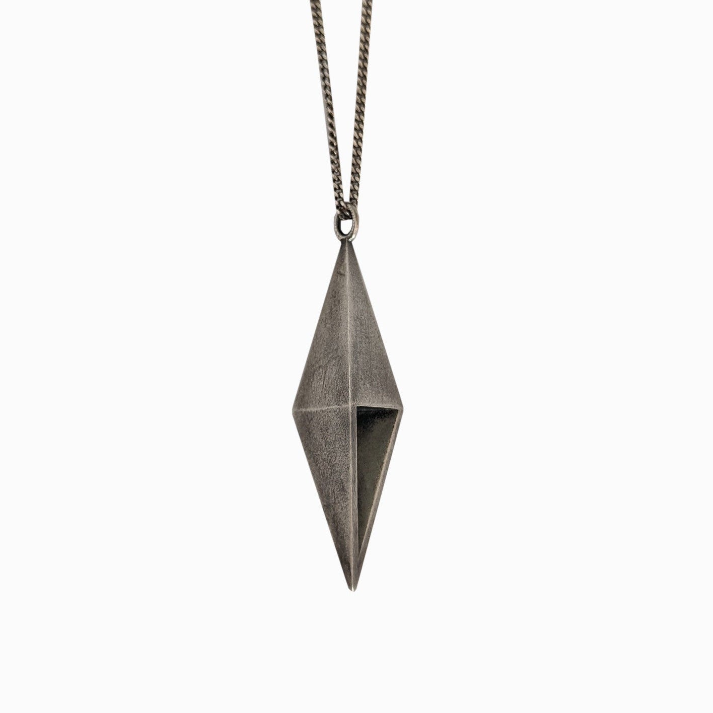 A metallic geometric pendant in a diamond shape, suspended from a sleek chain, against a plain white background.