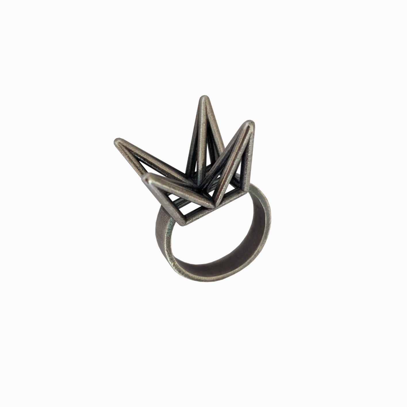 An abstract metal ring shaped like a crown with sharp peaks on top, set against a white background.