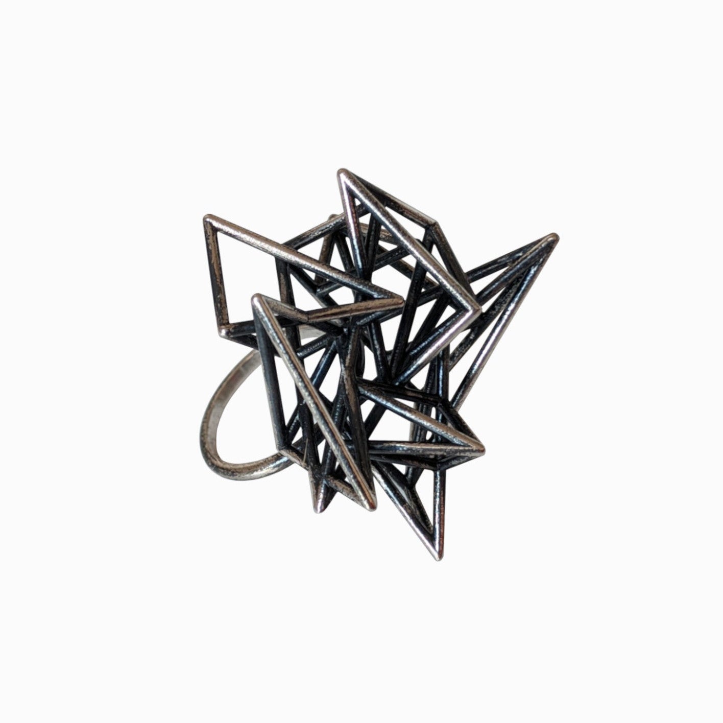 A sculptural geometric ring featuring intertwined metallic spikes, showcasing a modern, abstract design on a white background.