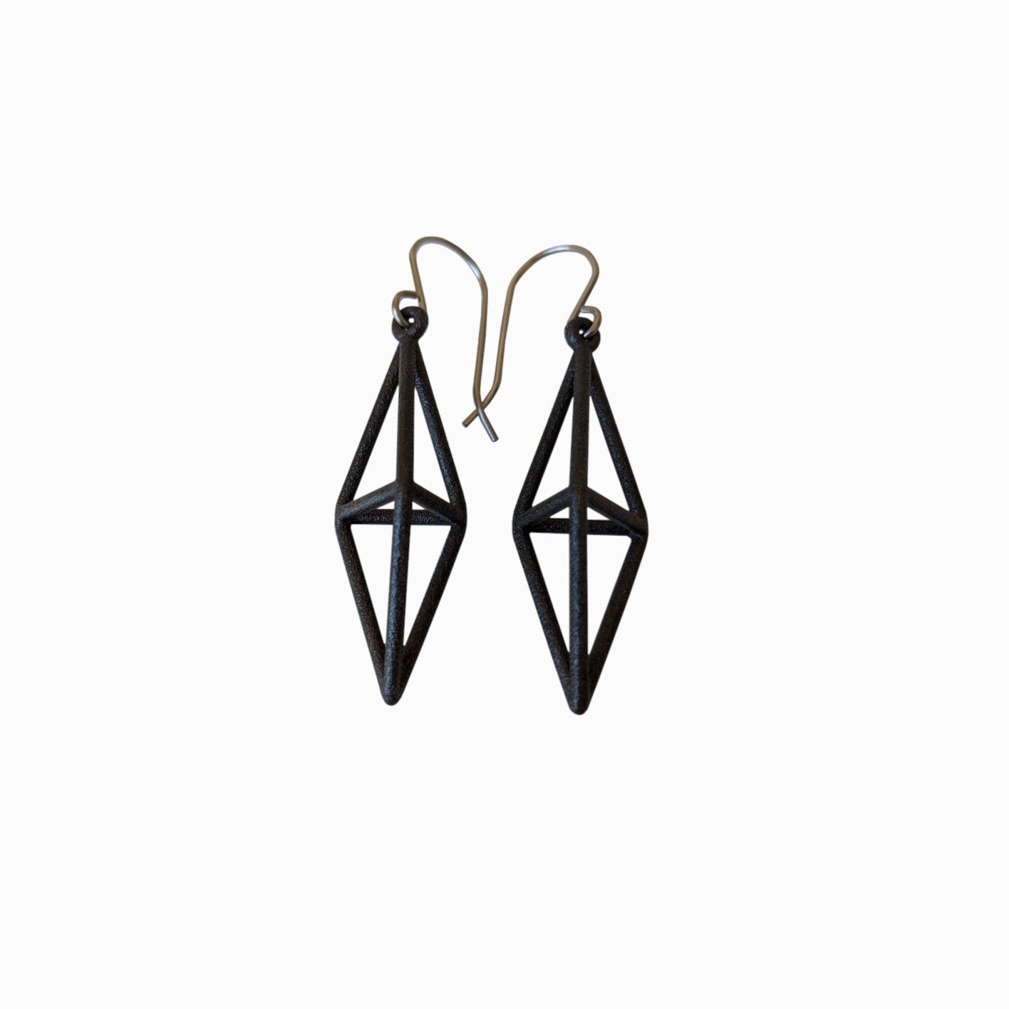 Black geometric earrings with a diamond shape and silver hooks, showcasing a modern, minimalist style.