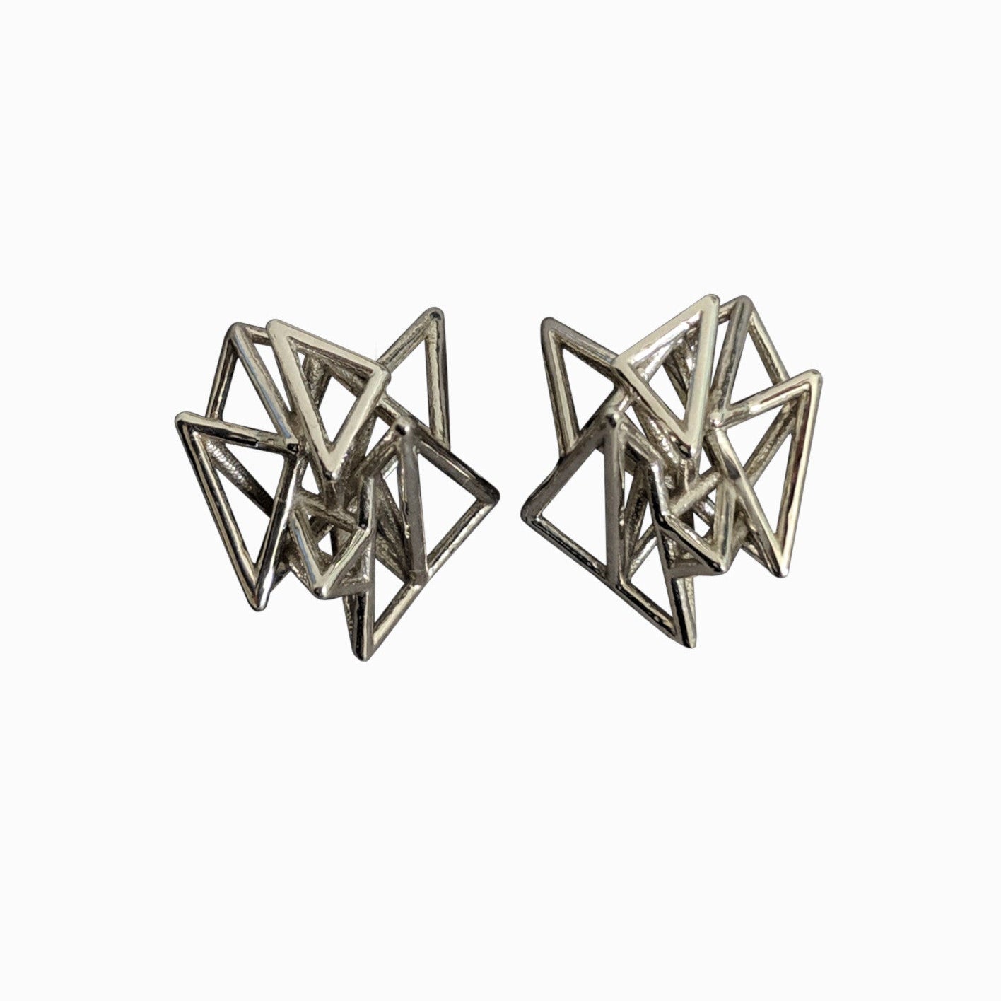 Geometric silver stud earrings featuring intersecting triangular designs, creating a modern and eye-catching look.