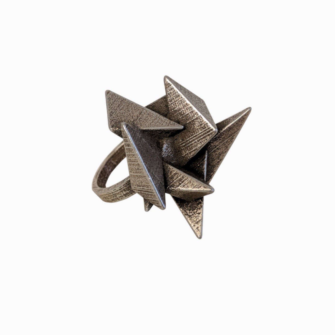 A unique, sculptural ring featuring a cluster of metallic triangular spikes in an artistic, abstract design.