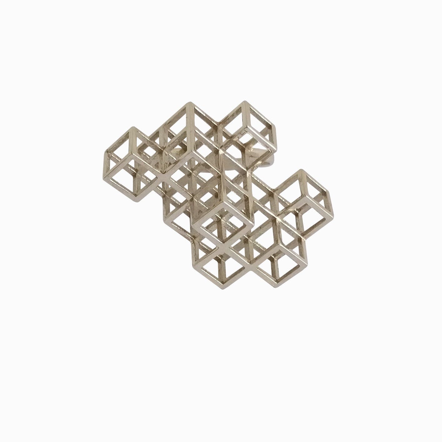 A complex, metallic sculpture composed of interconnected, open cubes arranged in an asymmetrical design against a white background.