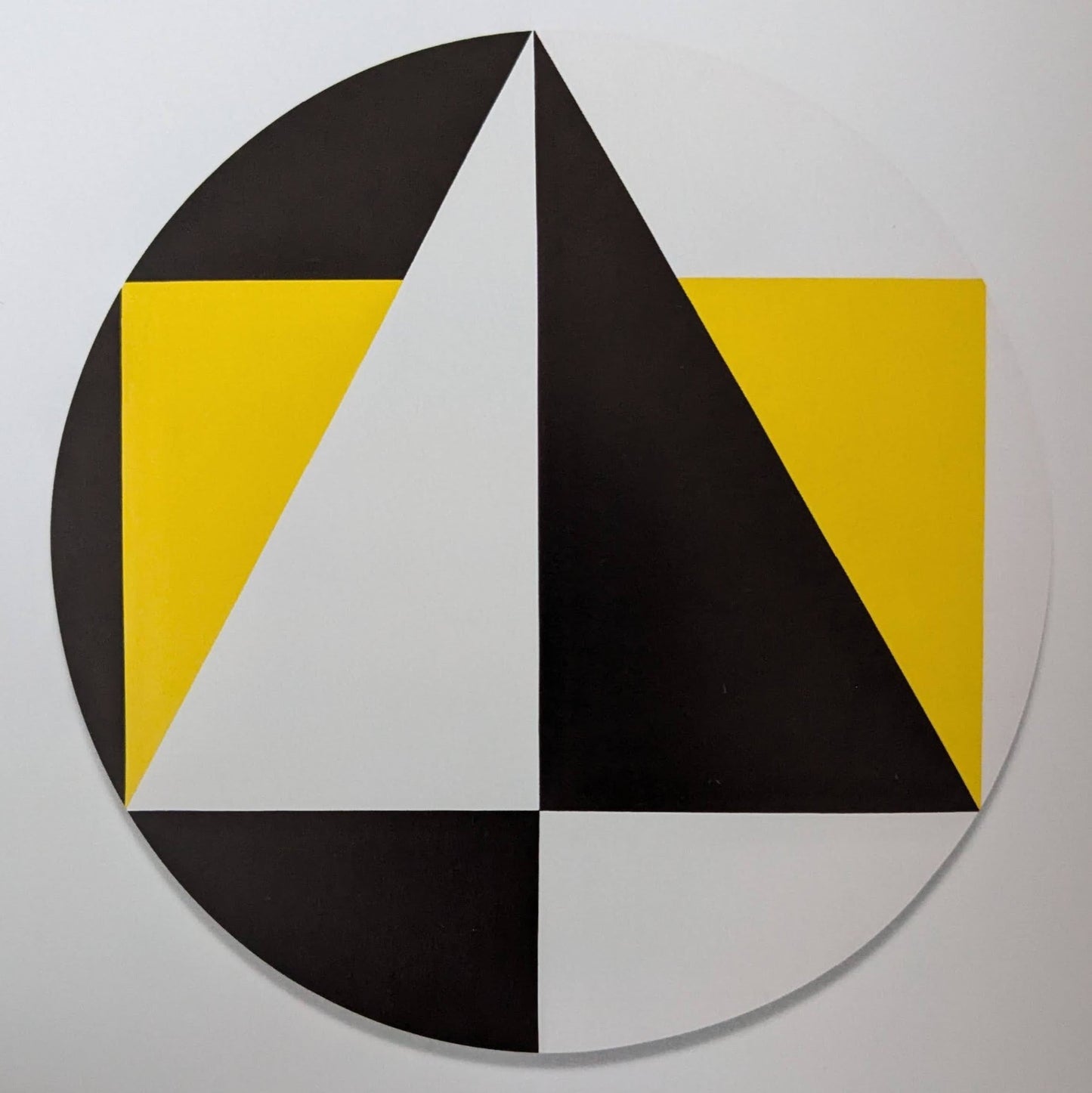 A circular geometric artwork featuring triangles and squares in black, white, and vibrant yellow, arranged in a balanced composition.