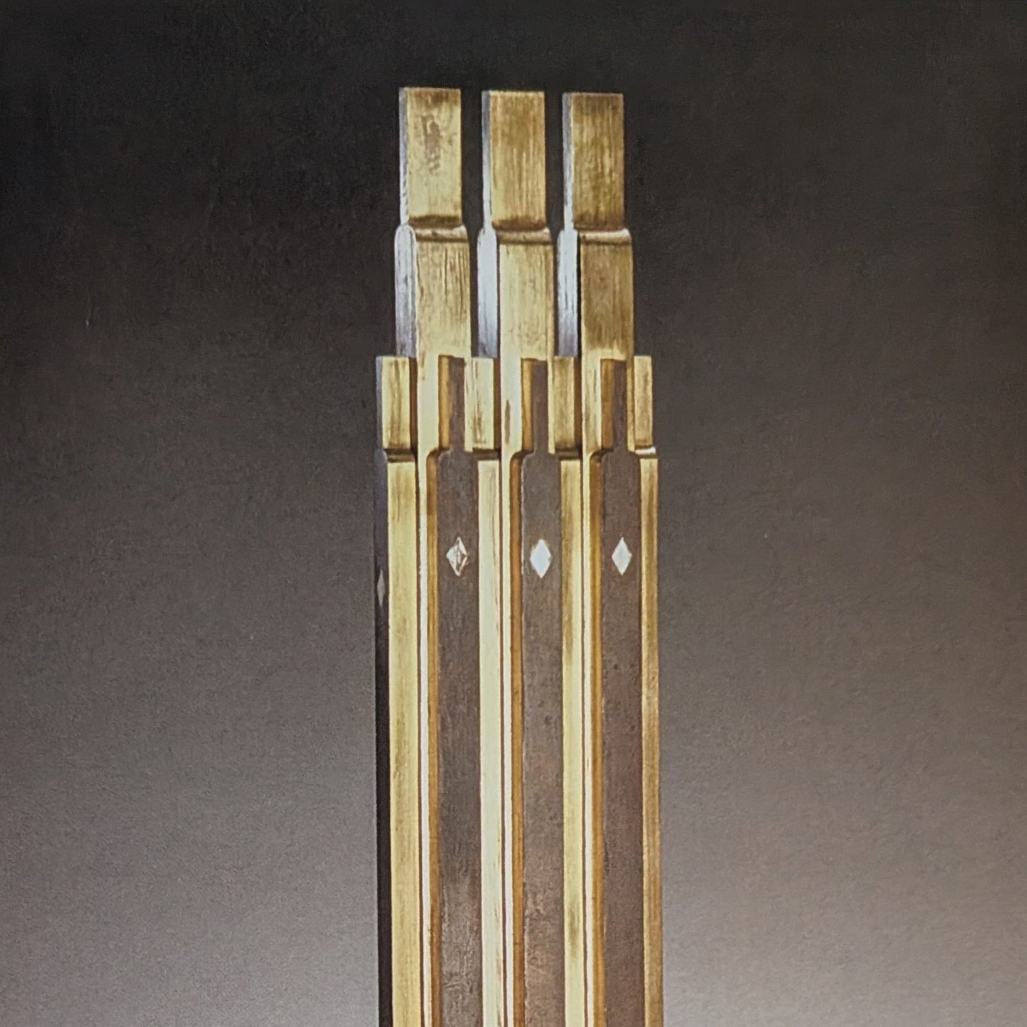 Three metal rectangles standing vertically against a dark background.