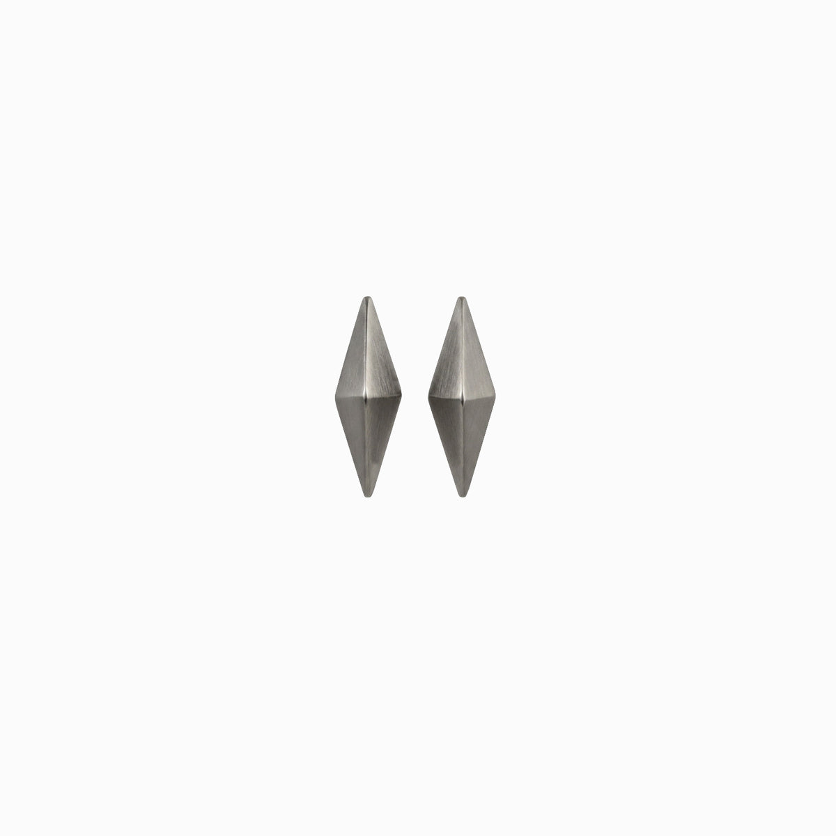 A pair of silver geometric earrings shaped like elongated diamonds against a white background.