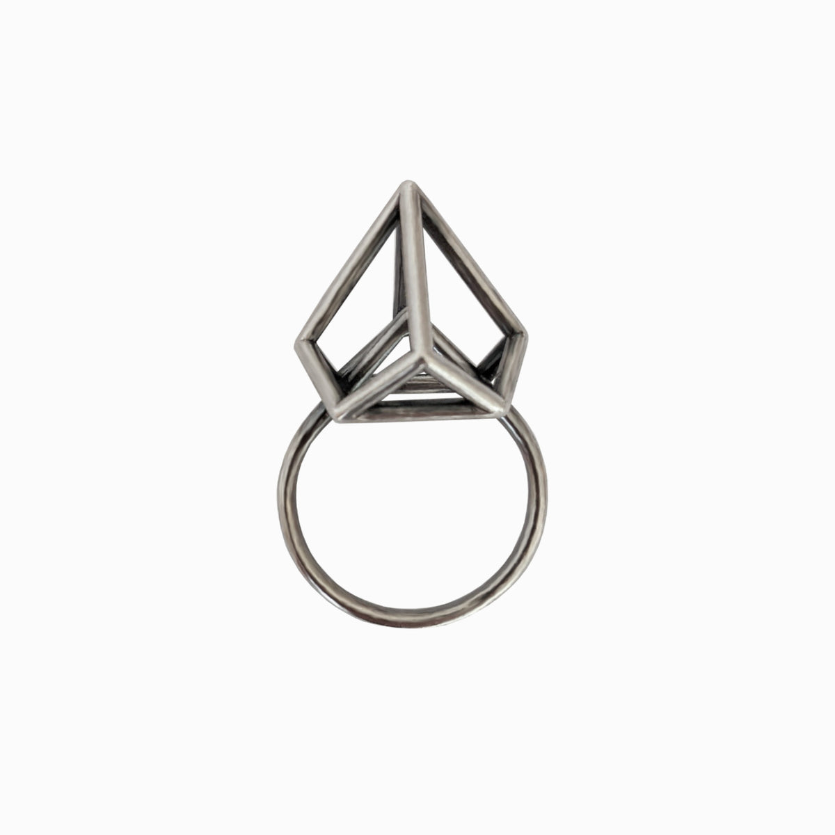 A silver ring with a geometric, triangular prism design set atop the band, isolated on a white background.