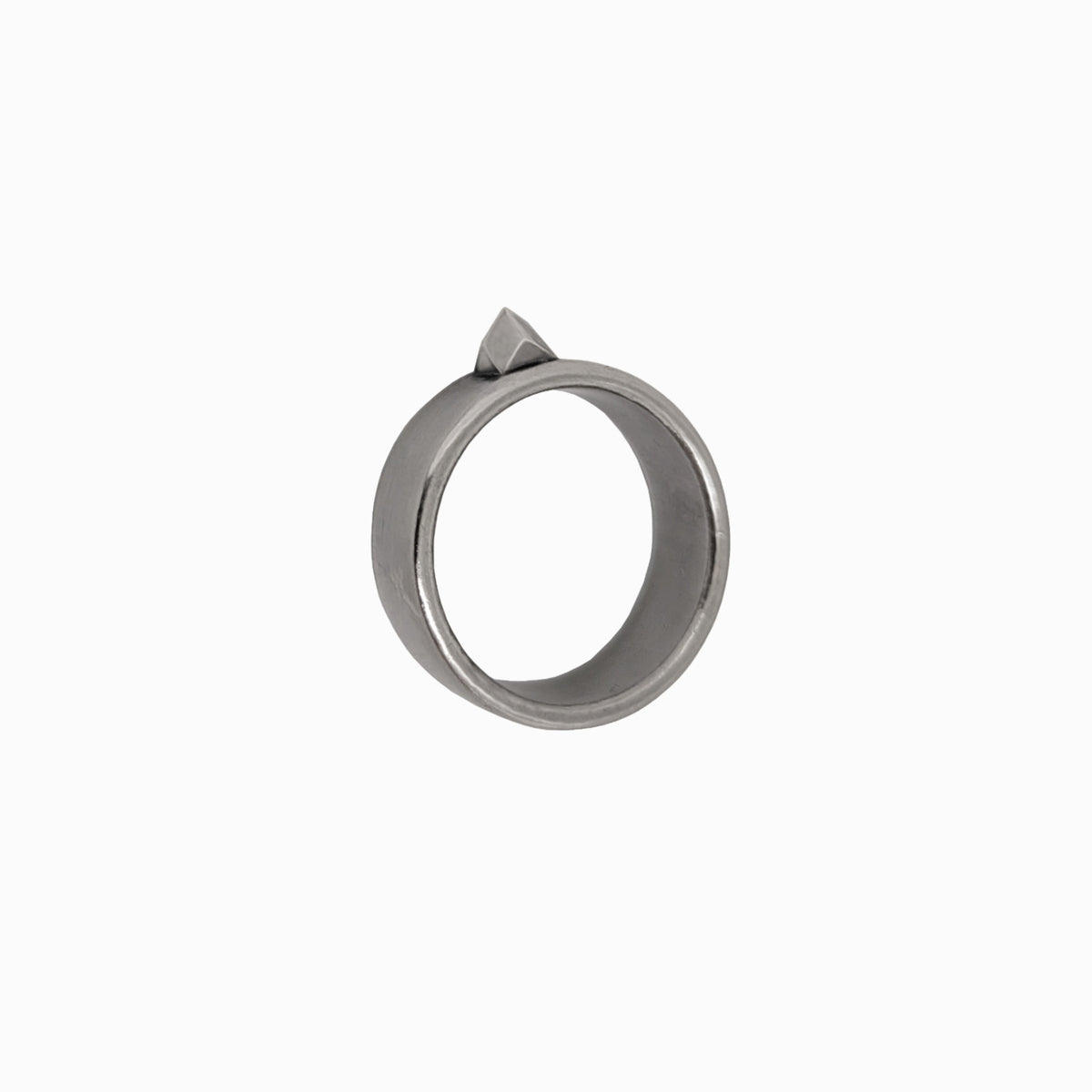 A minimalist silver-toned metal ring with a small pointed triangular accent on top, shown against a plain white background.