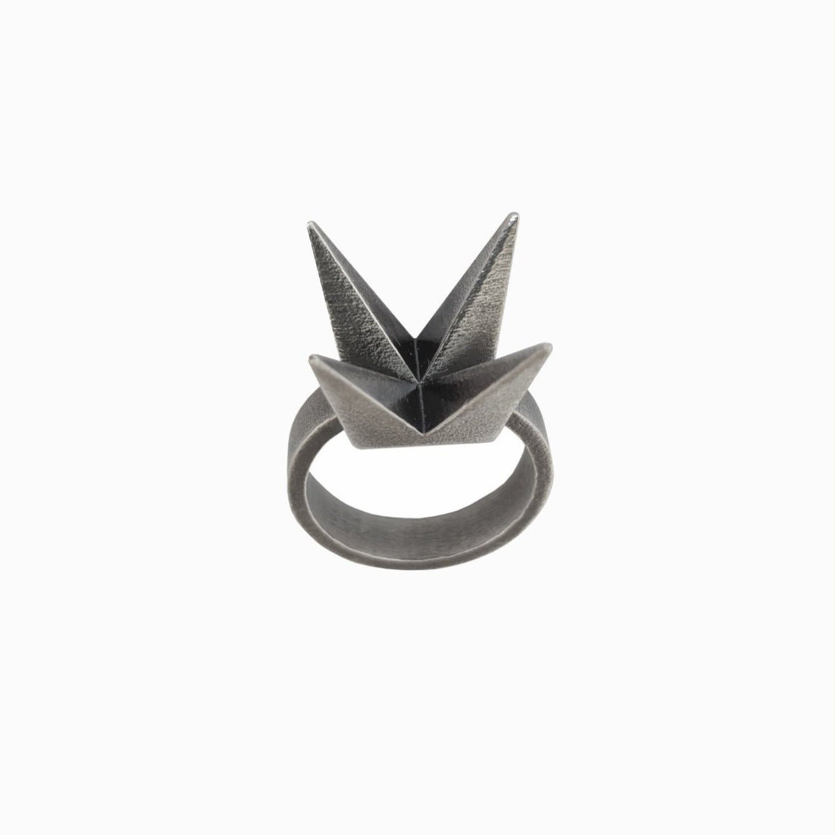 A unique geometric ring featuring two pointed, origami-inspired peaks in a matte metallic finish.