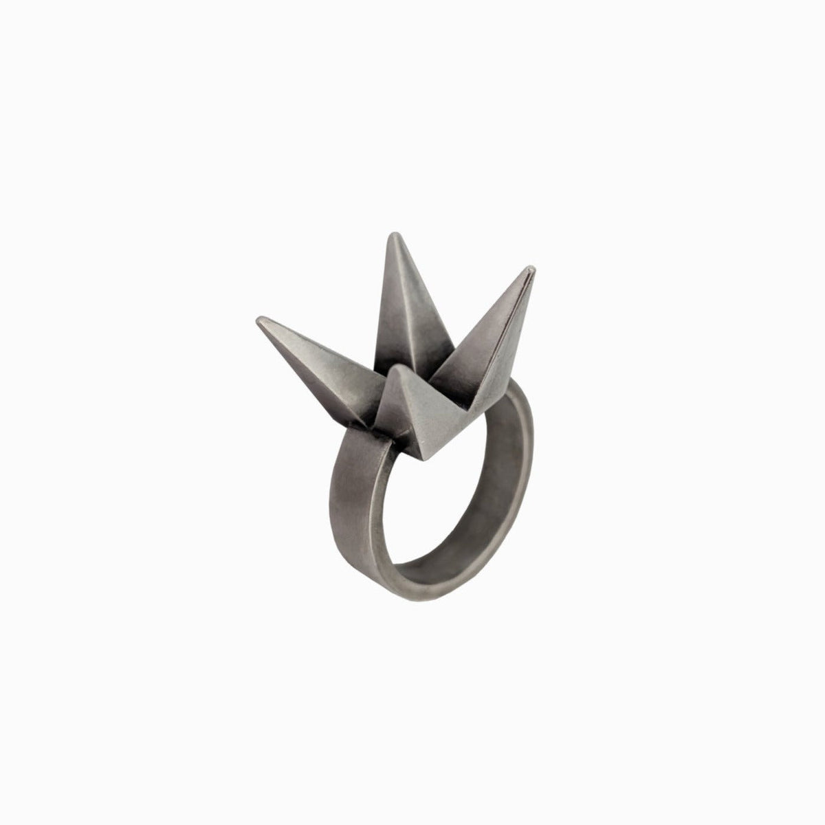 A unique geometric ring featuring two pointed, origami-inspired peaks in a matte metallic finish.