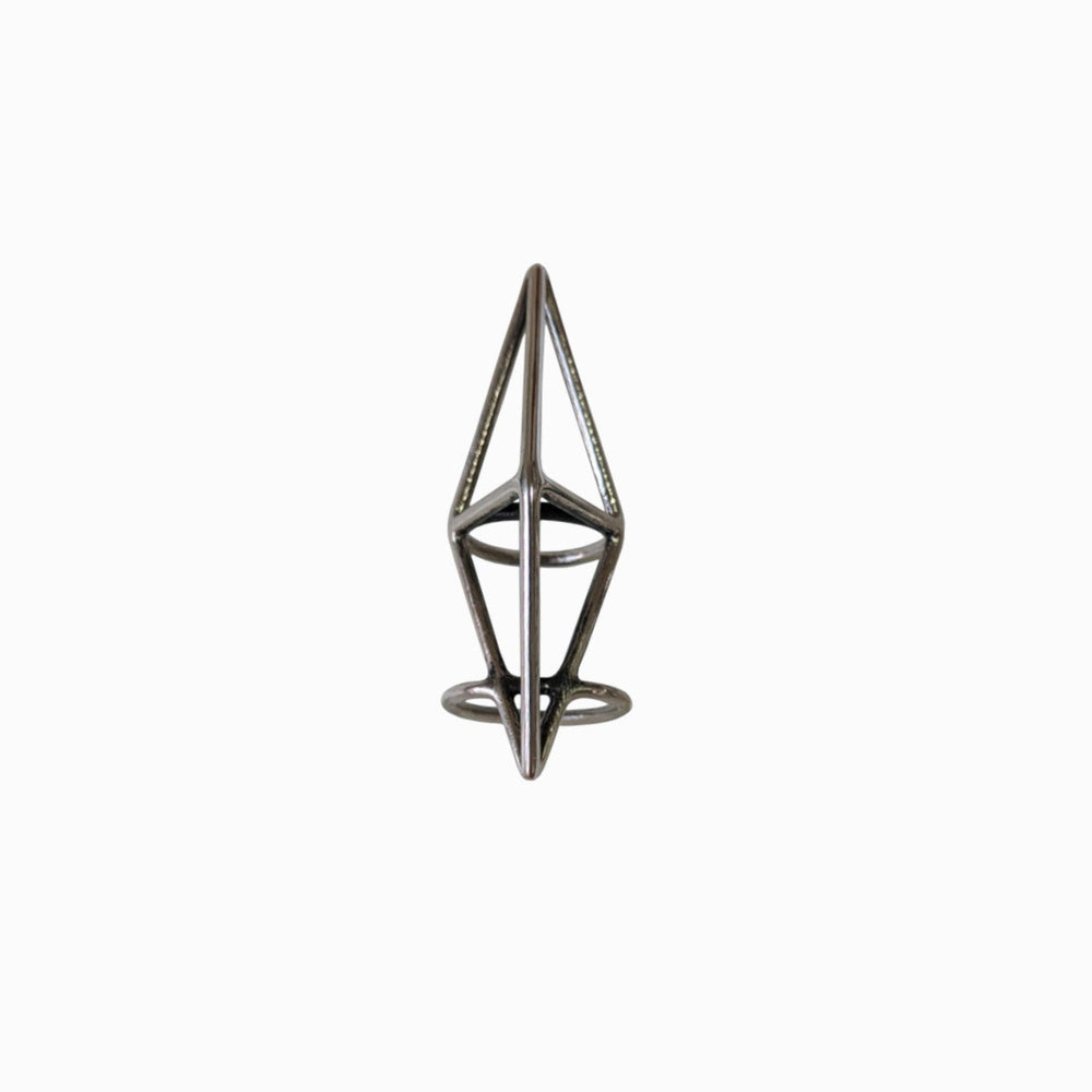 
                  
                    A geometric metal ring featuring a minimalist design with triangular and circular elements on a plain white background.
                  
                