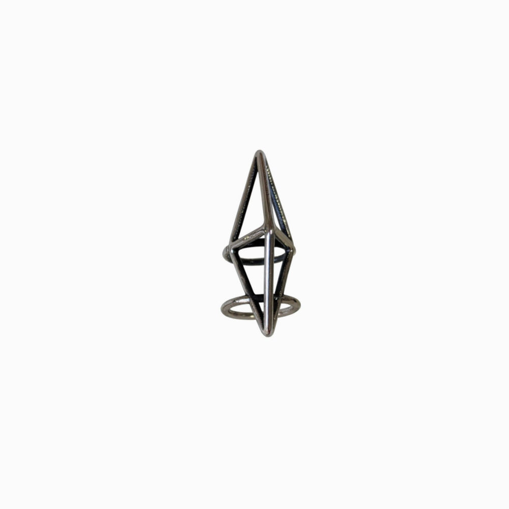 
                  
                    A geometric metal ring featuring a minimalist design with triangular and circular elements on a plain white background.
                  
                