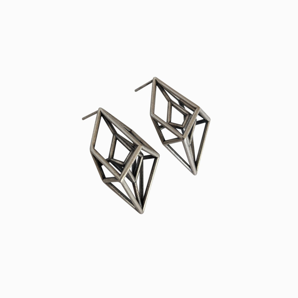 
                  
                    A pair of metallic geometric earrings with an intricate, angular design, showcasing a modern and artistic style.
                  
                