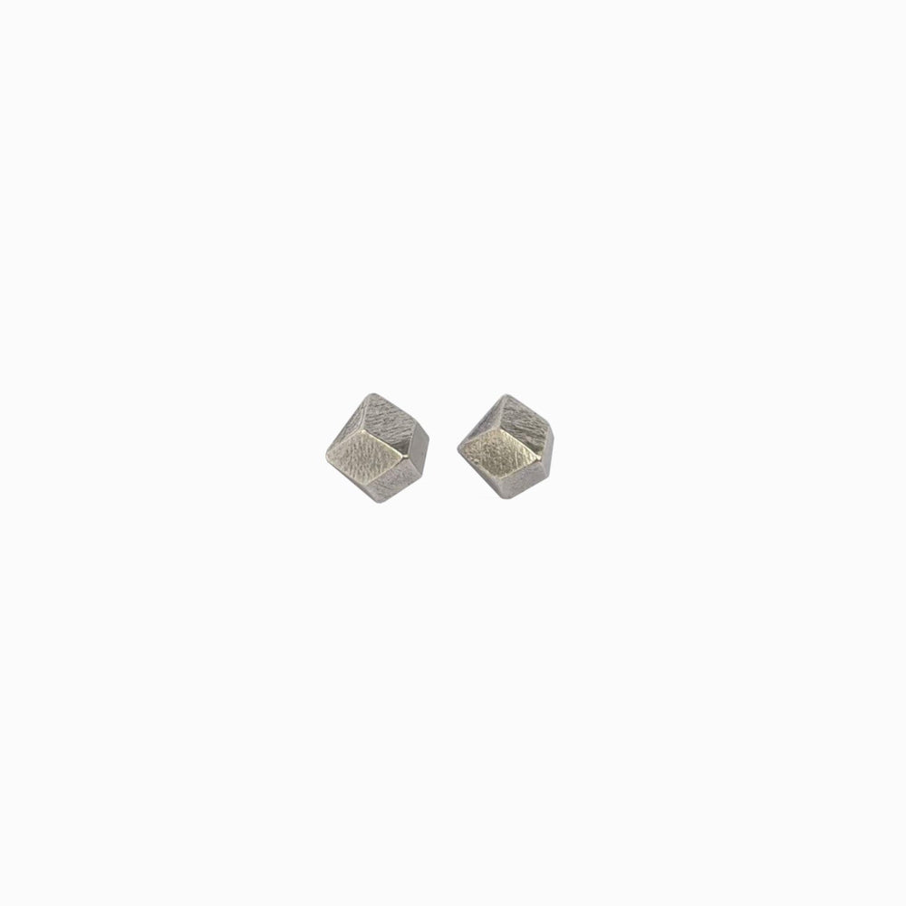 
                  
                    Two geometric silver studs with a textured surface, reflecting light, set against a white background.
                  
                
