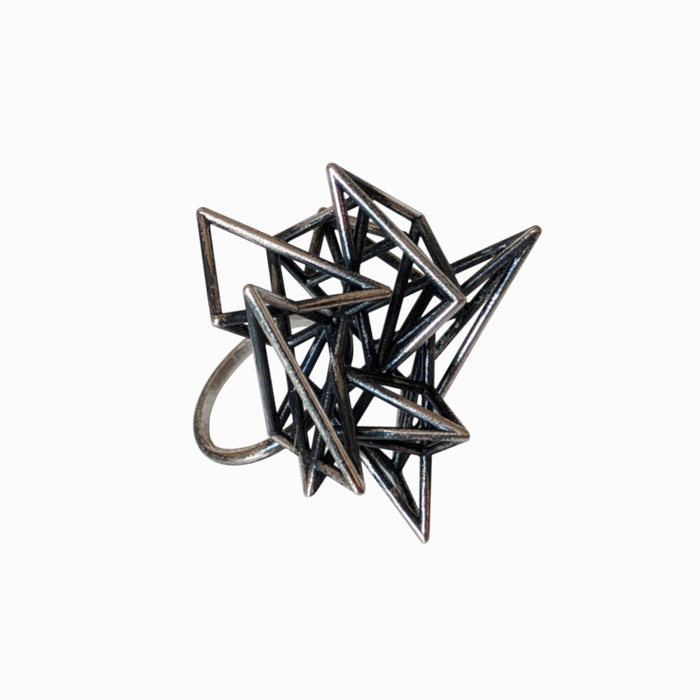A sculptural geometric ring featuring intertwined metallic spikes, showcasing a modern, abstract design on a white background.