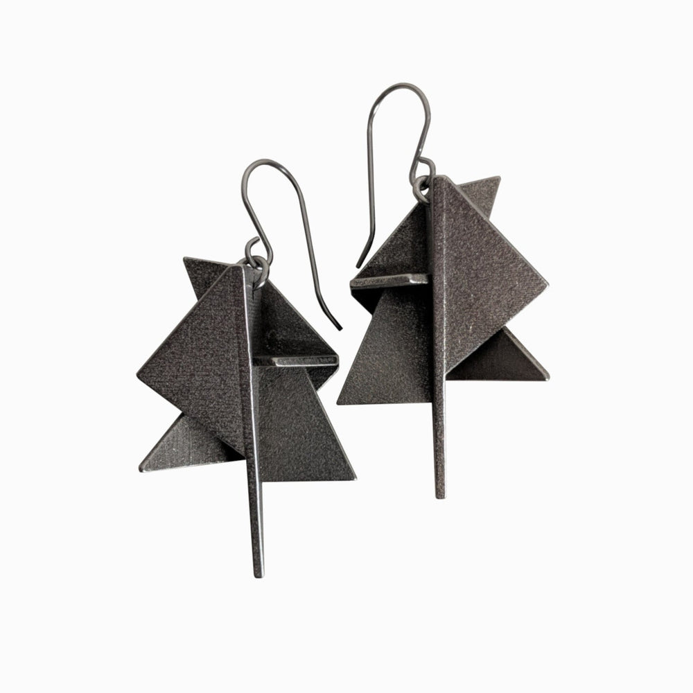 
                  
                    Two asymmetrical, geometric black earrings featuring layered triangular shapes and sleek hooks.
                  
                