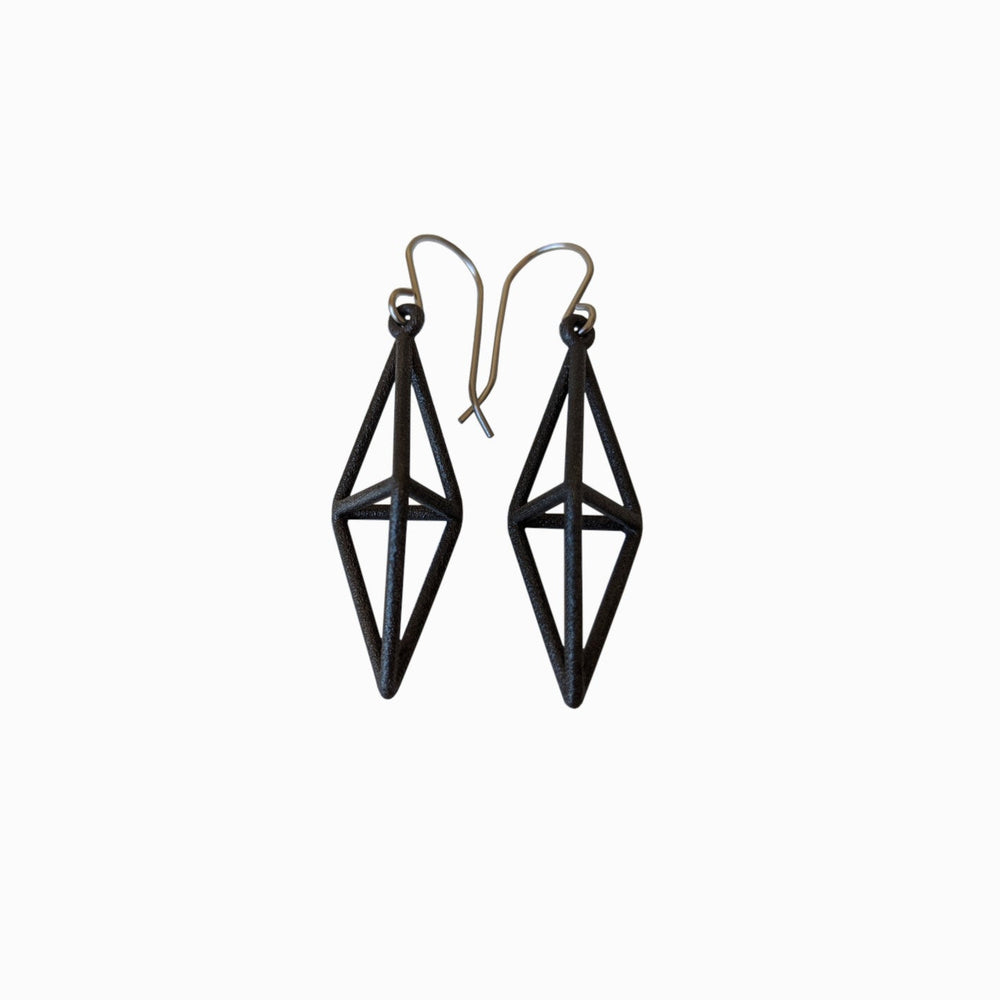 Black geometric earrings with a diamond shape and silver hooks, showcasing a modern, minimalist style.